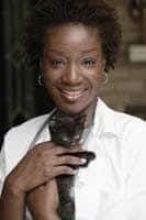 Female veterinarian holding a black kitten.
